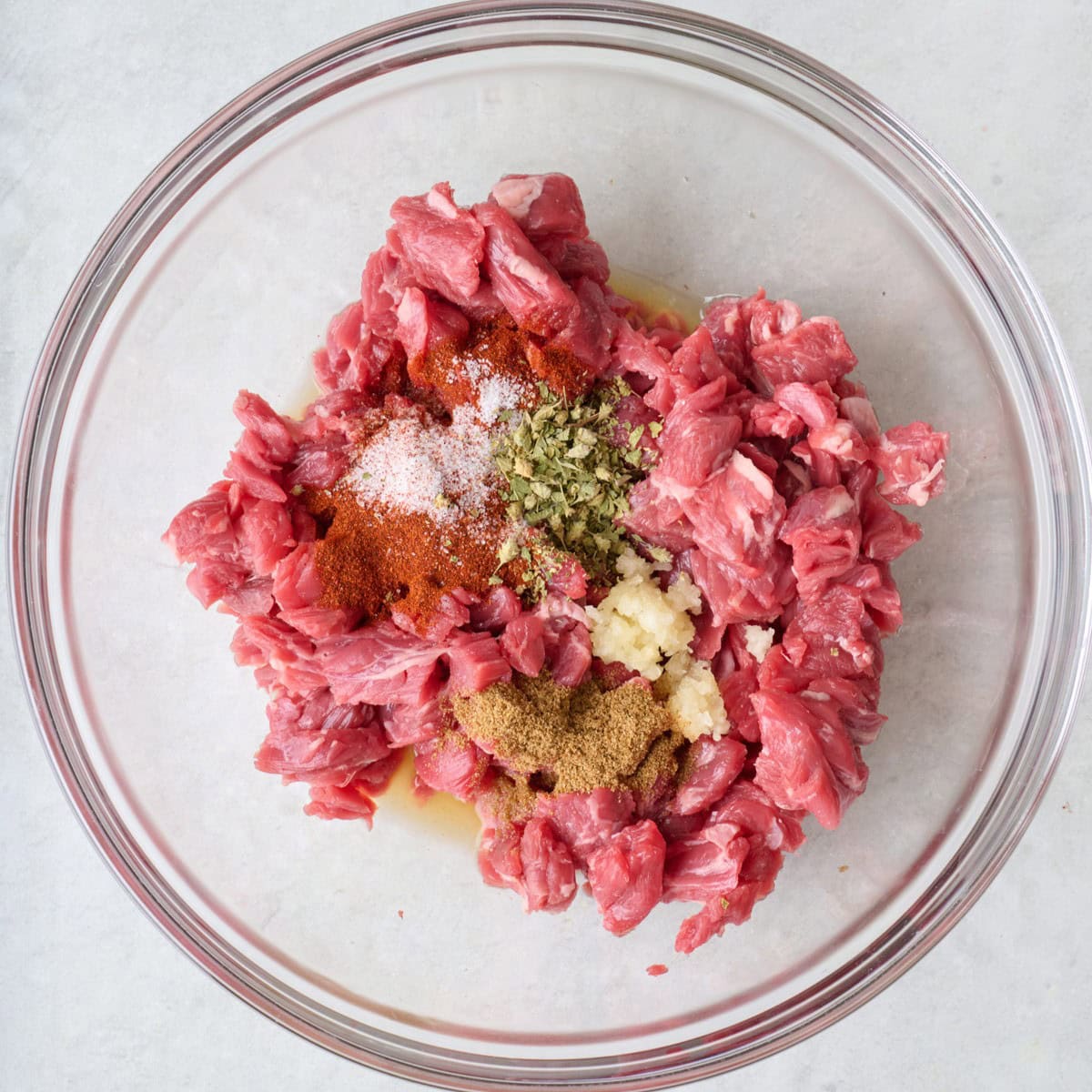 Beef in a bowl with seasonings added.