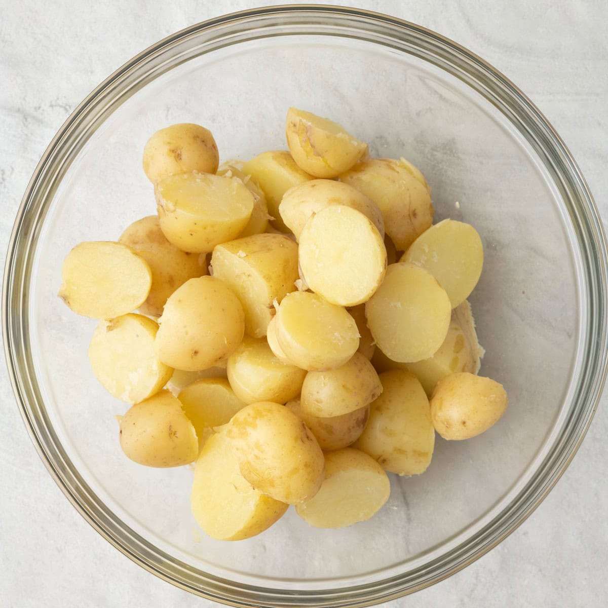 Cooked potatoes added on top in the same bowl before tossing together.