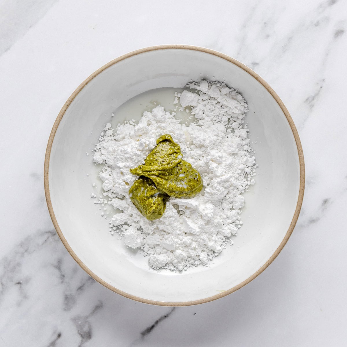 Powdered sugar, pistachio butter and lemon juice in a small bowl.