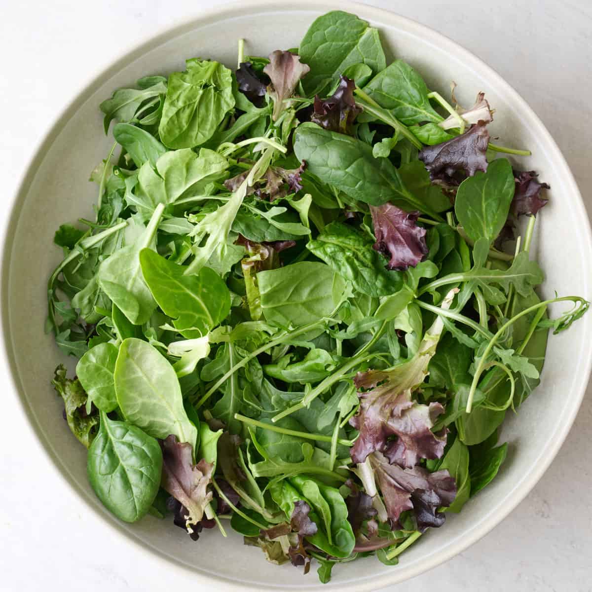 Mixed greens in a large bowl.