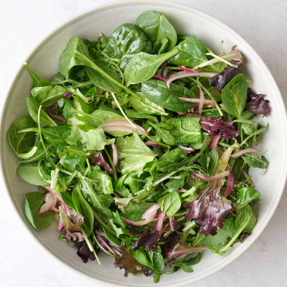 Mixed salad greens after tossing with dressing.