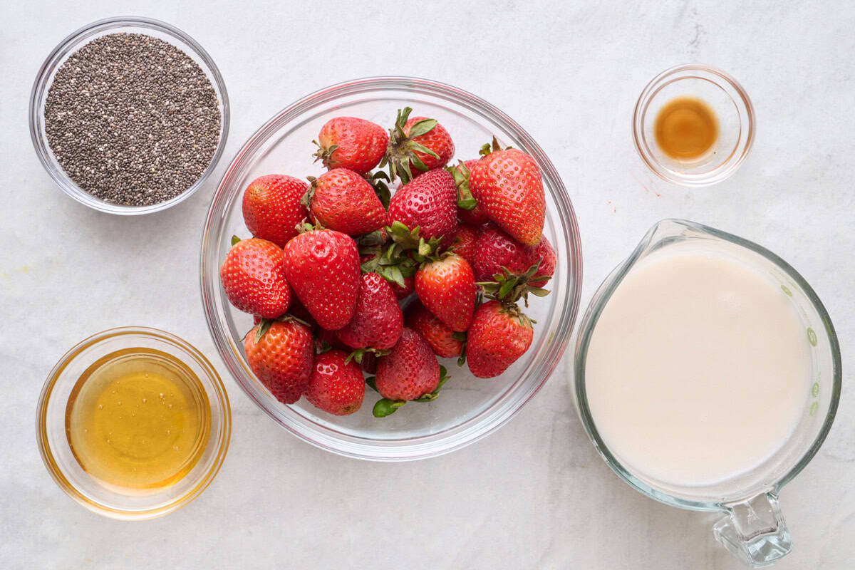 Ingredients for recipe: fresh strawberries, chia seeds, honey, vanilla and milk.