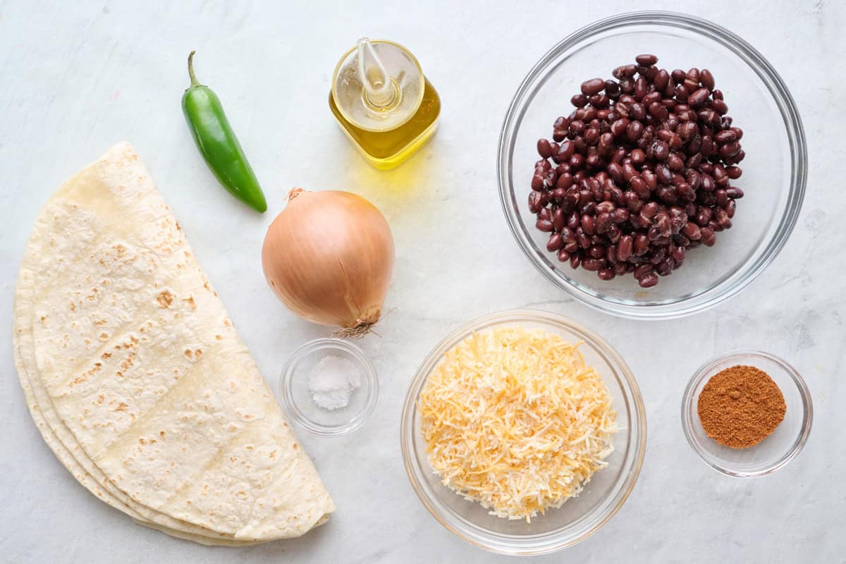 Ingredients for recipe: large tortillas, jalapeno, onion, salt, oil, cheese, seasoning, and black beans.