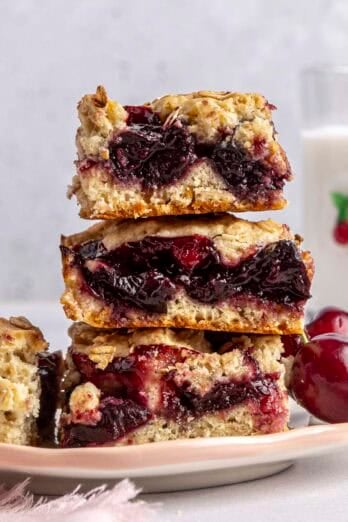 Homemade cherry bars stacked up on a plate.