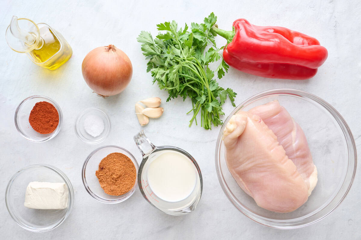 Ingredients for recipe: chicken breasts, oil, onion, parsley, red bell pepper, garlic, paprika, salt, Cajun seasoning, milk, and cream cheese.