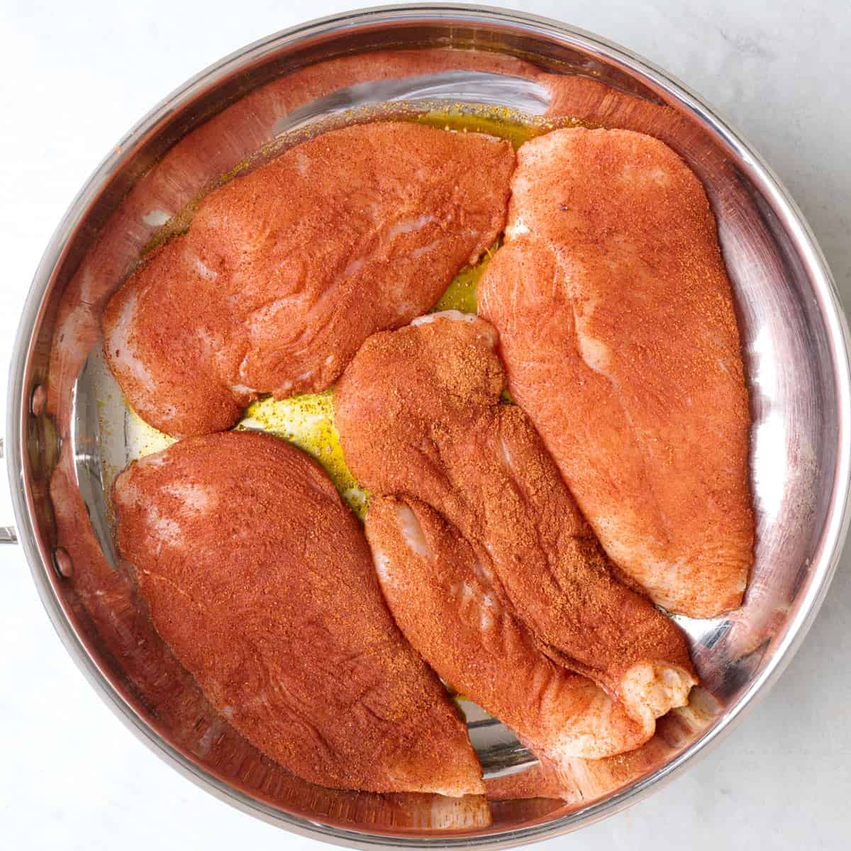 Seasoned chicken added to skillet.