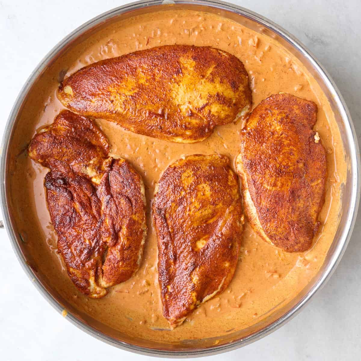 After sauce has combined and simmered until slightly thickened with chicken and juices added back.