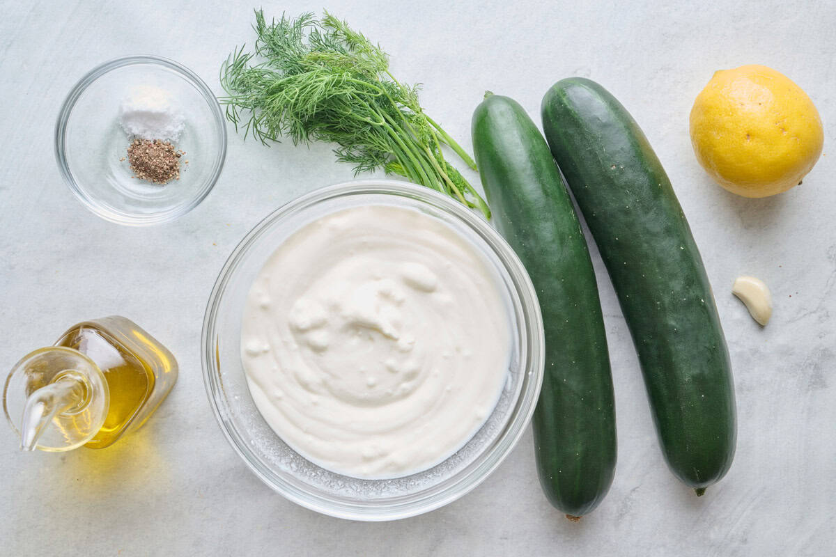 Ingredients for recipe: salt and pepper, oil, fresh dill, yogurt, cucumbers, garlic, and lemon.