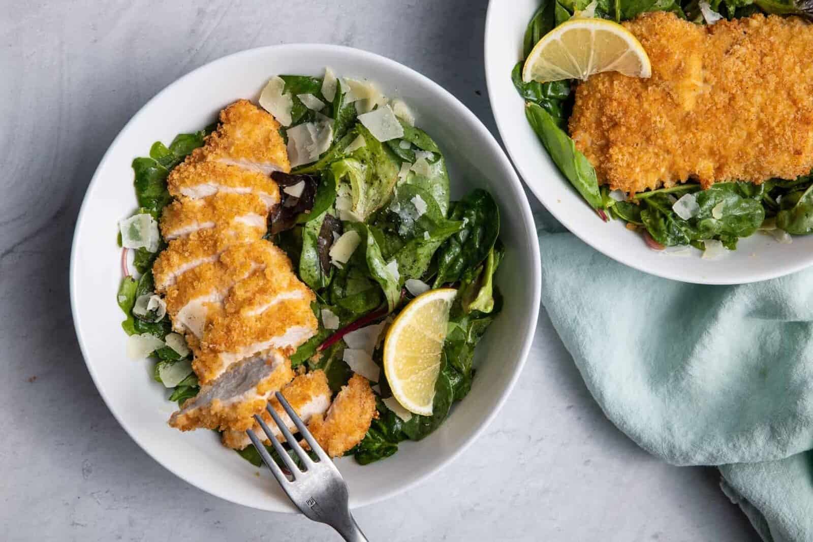 Fried Chicken Parmesan Salad in two bowls with fork grabbing a bite