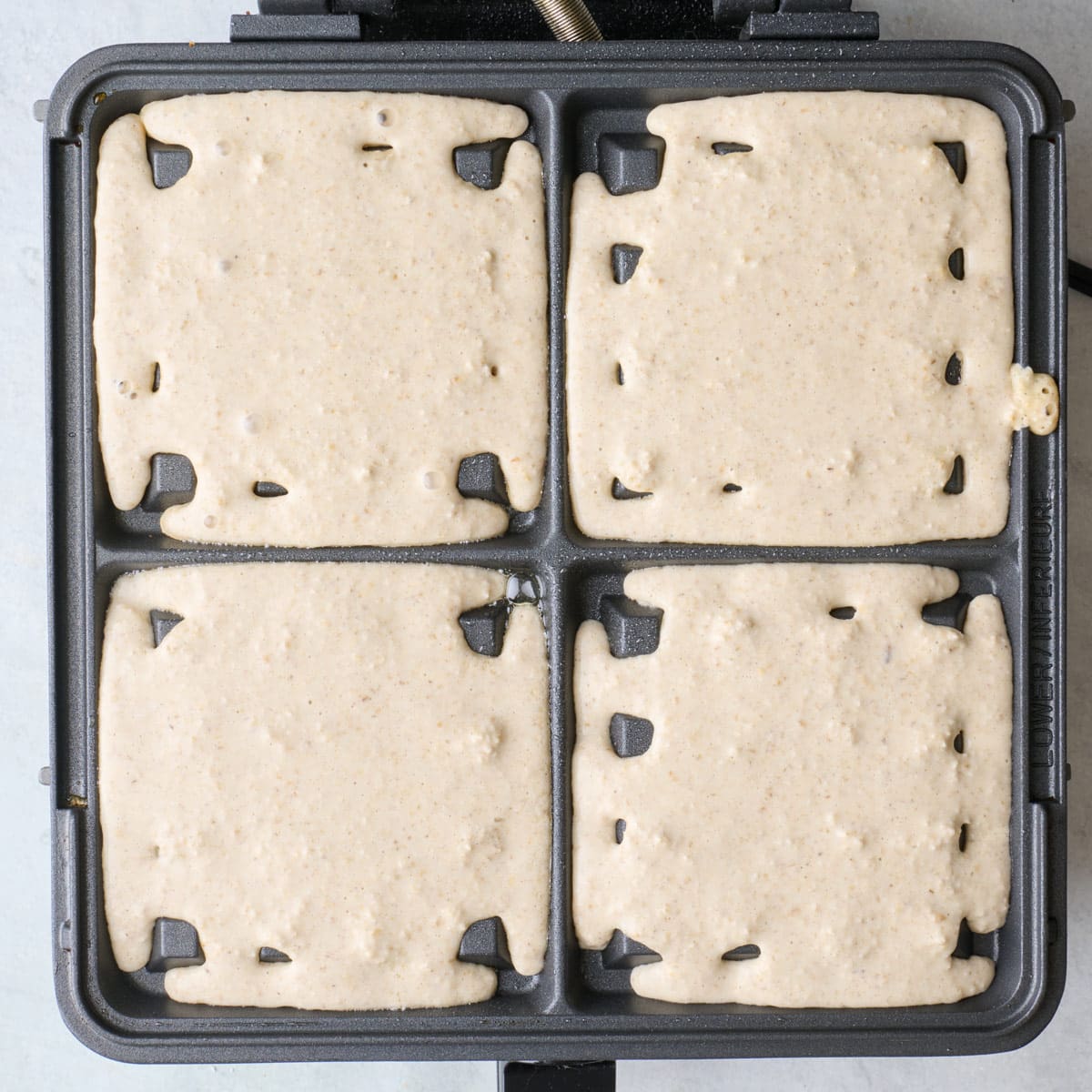 Batter added to waffle iron before cooking.