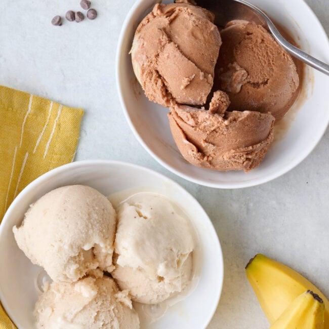 Two bowls of homemade protein ice cream, one vanilla, one chocolate.