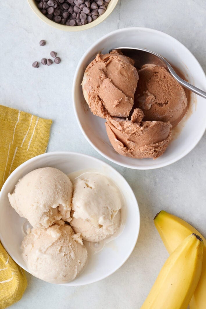 Two bowls of homemade protein ice cream, one vanilla, one chocolate.