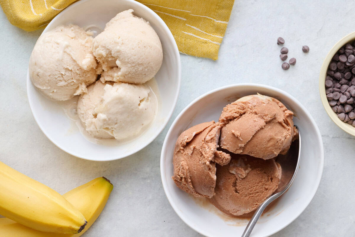 Bowl of vanilla protein ice cream and bowl of chocolate flavor with bananas nearby.