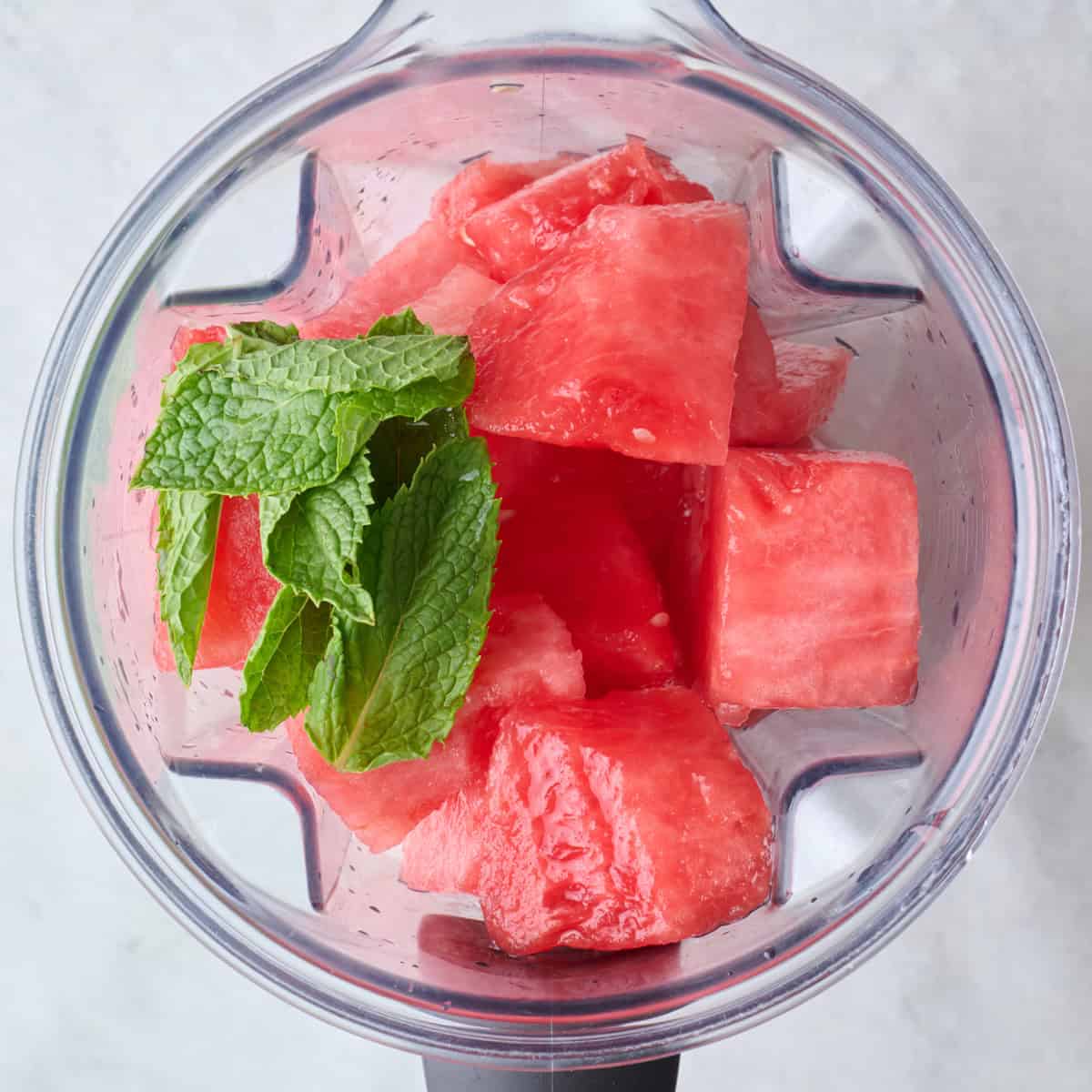 Watermelon cubes, lime juice and mint in a blender with water before blending.