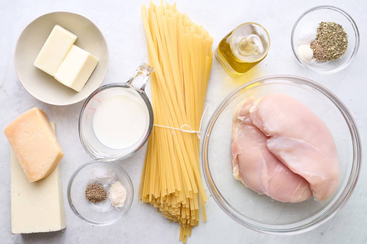 Ingredients for recipe: fettuccine pasta, butter, milk, seasonings, Pecorino Romano cheese block, and Parmesan cheese block.