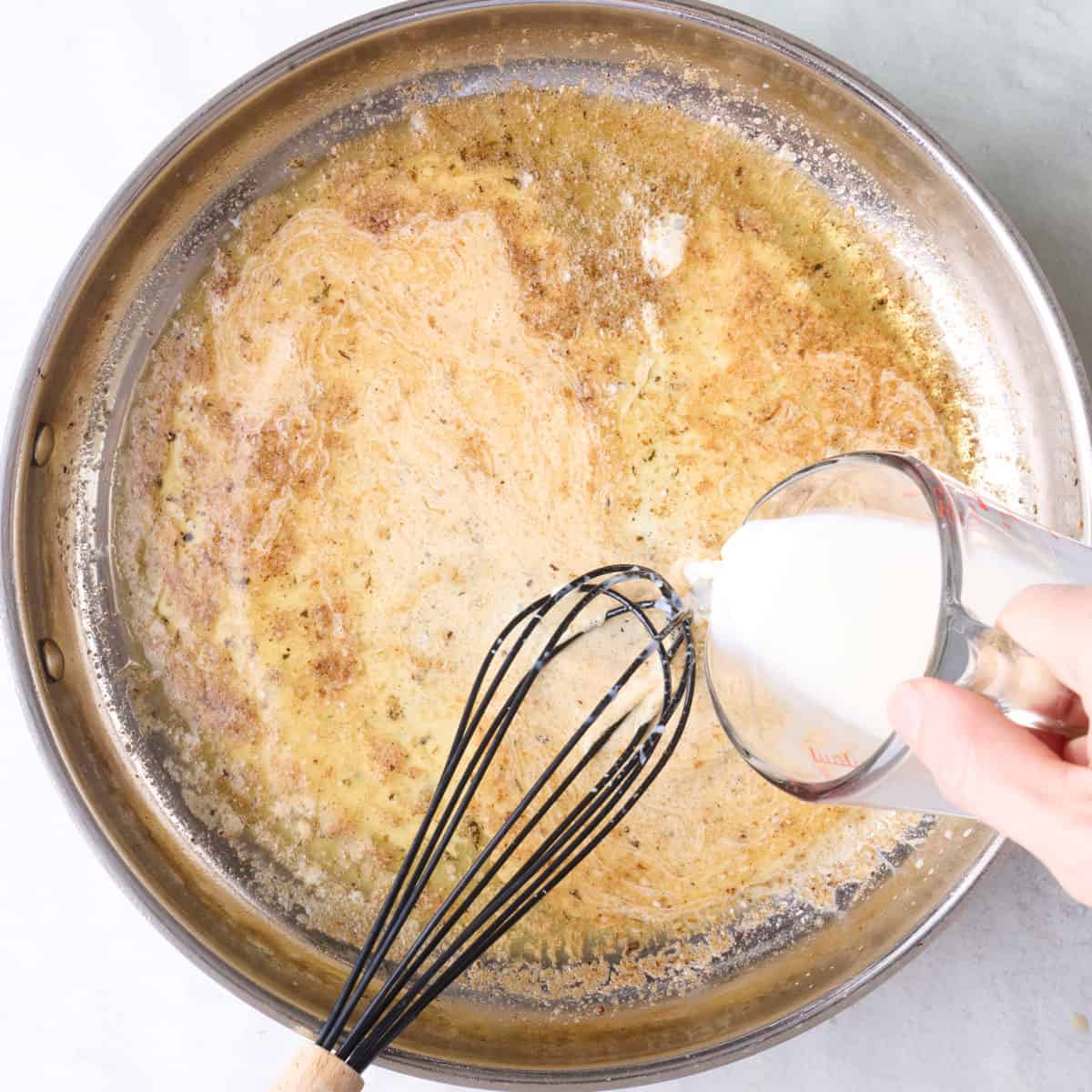 Whisking milk into butter and chicken drippings.