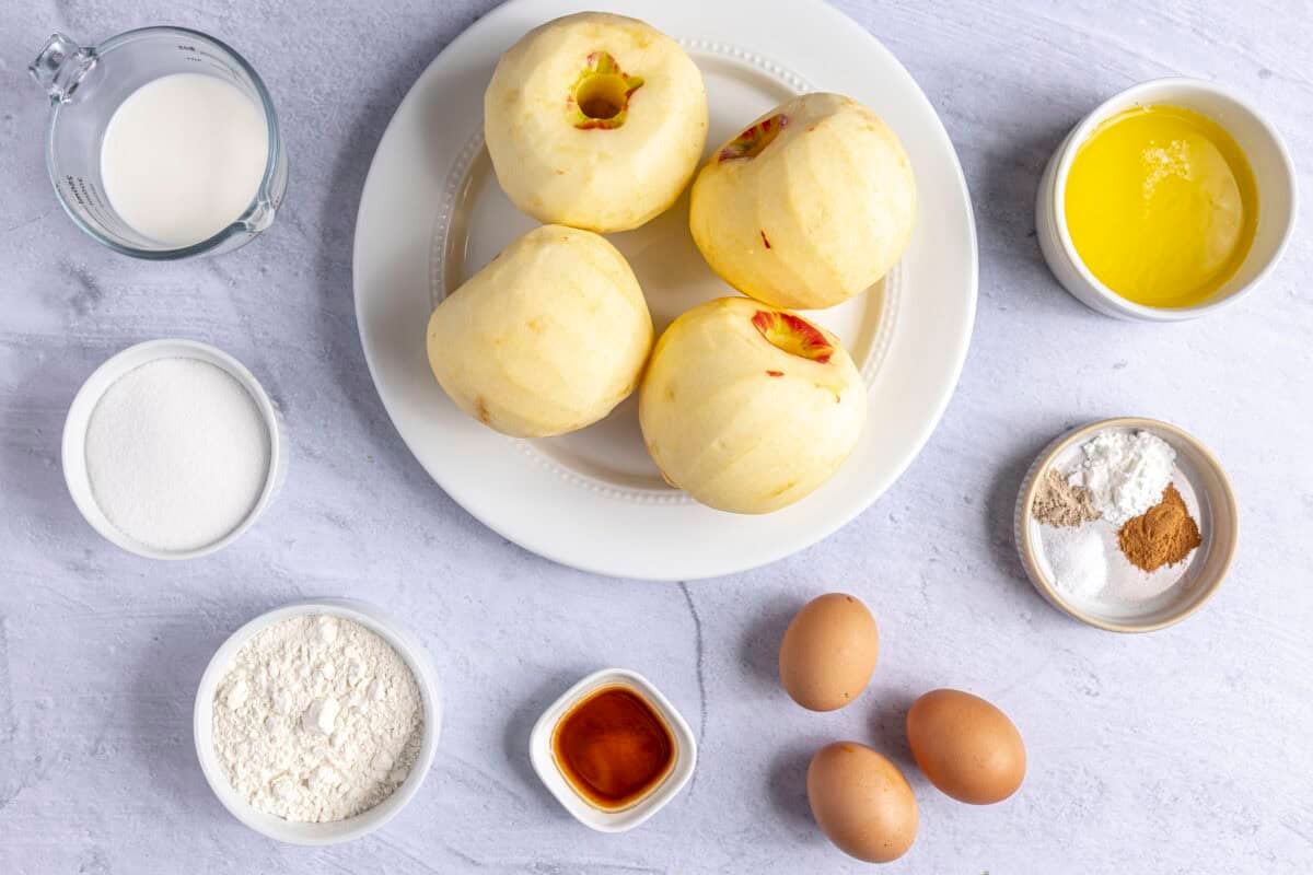 Ingredients for recipe: peeled whole apples, milk, sugar, flour, vanilla, eggs, spices, and melted butter.