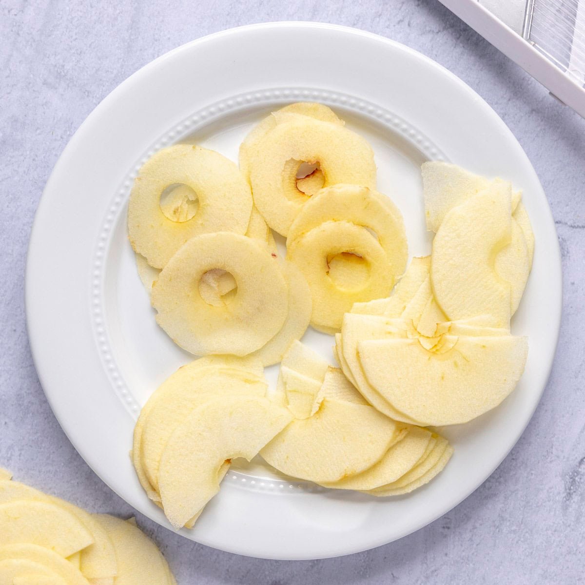 Thinly sliced apple rounds and halves on a plate.