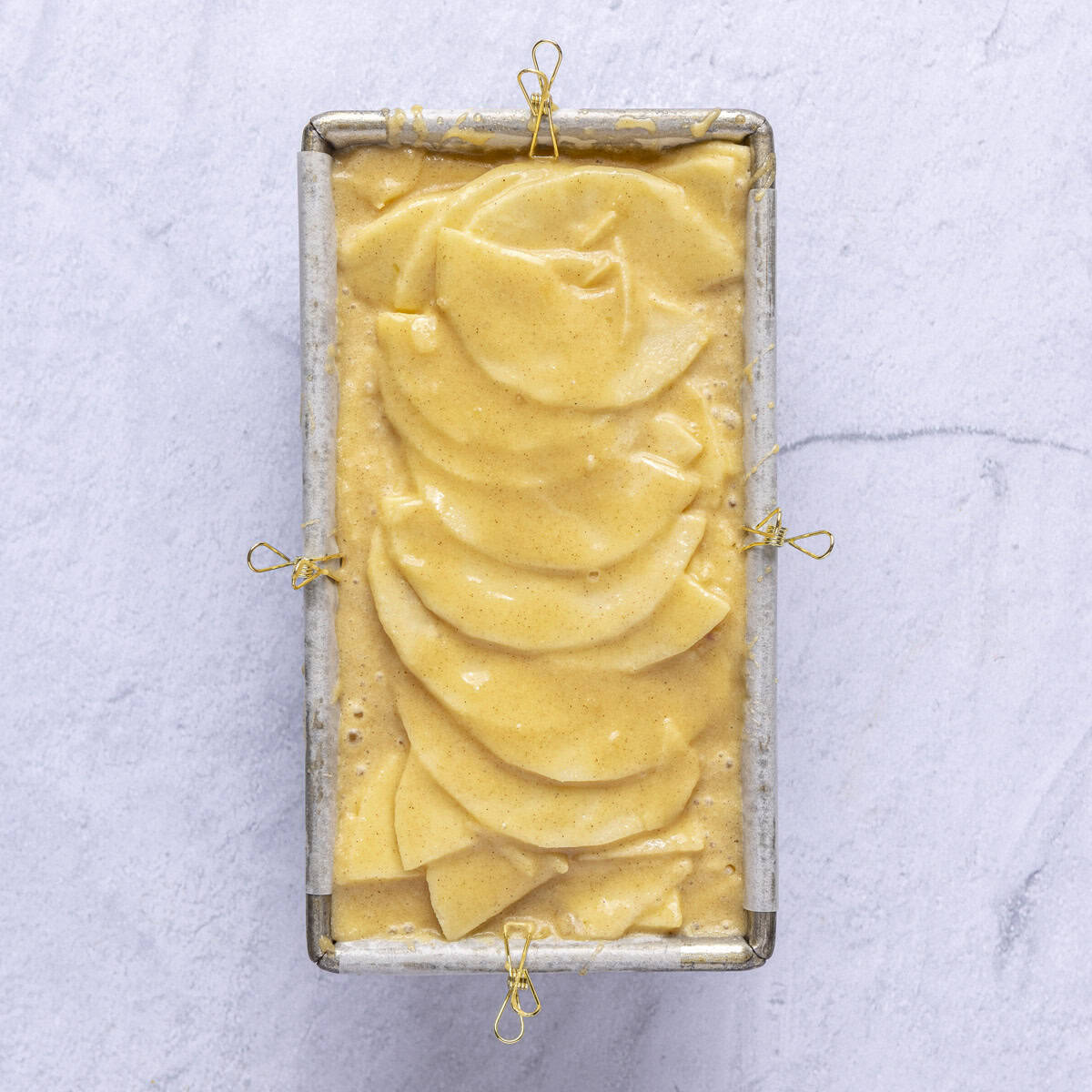 After all apples are added with the reserved apples slices fanned out on top and remaining batter poured over.