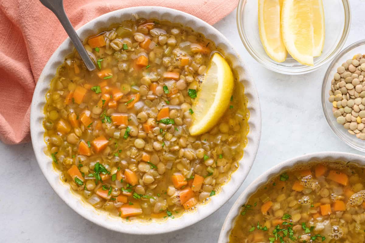 Homemade lentil soup in a bowl with a lemon wedge on top.