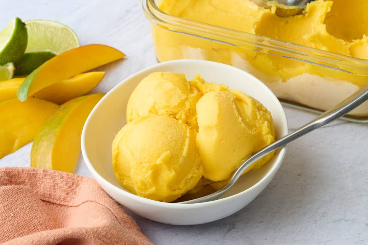 Homemade mango sorbet scooped into a serving bowl.
