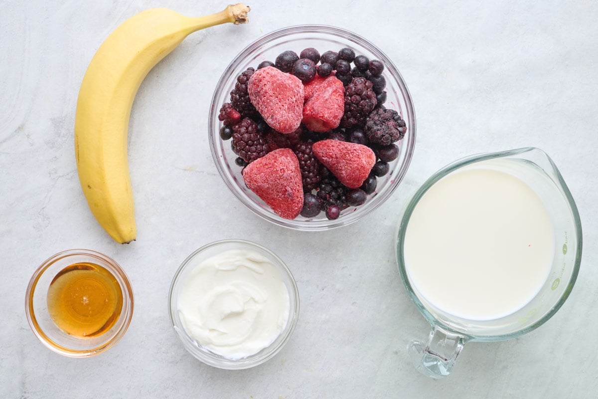 Ingredients for recipe: banana, frozen mixed berries, honey, yogurt and milk.