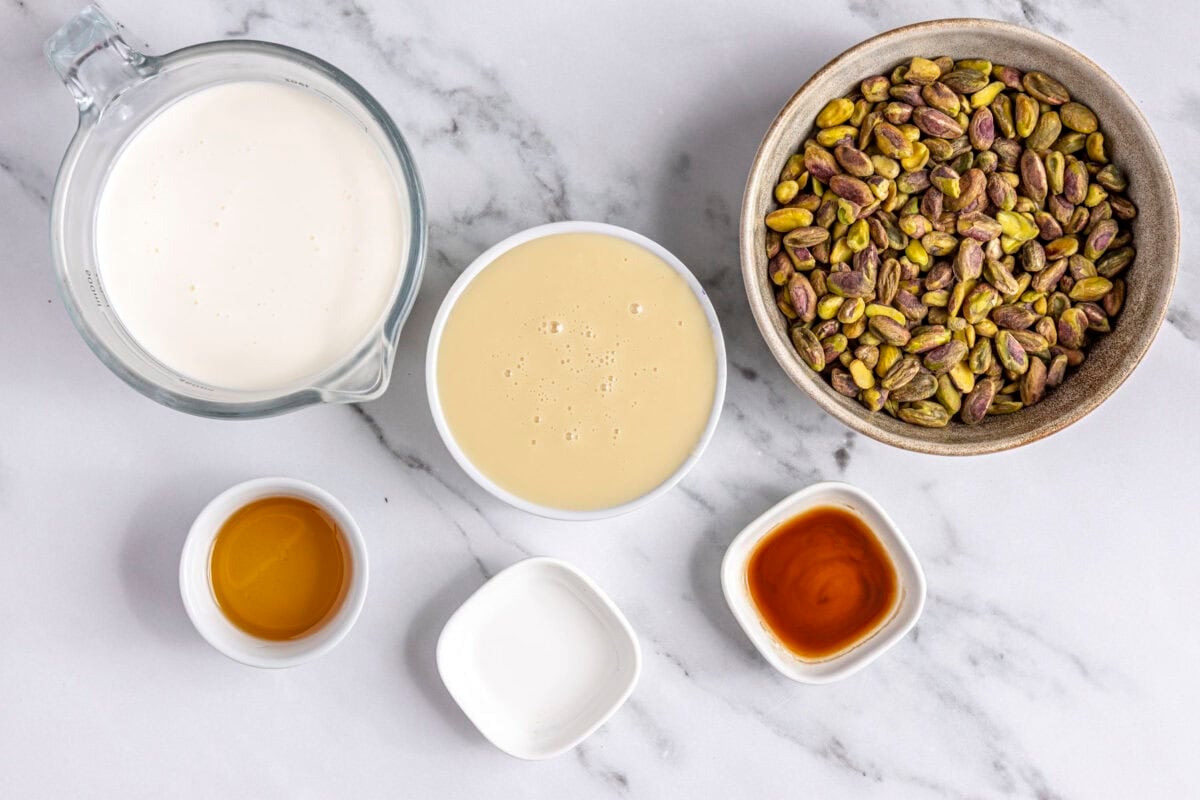 Ingredients for recipe before prepping: heavy whipping cream, sweetened condensed milk, honey, vanilla, almond, and pistachios.