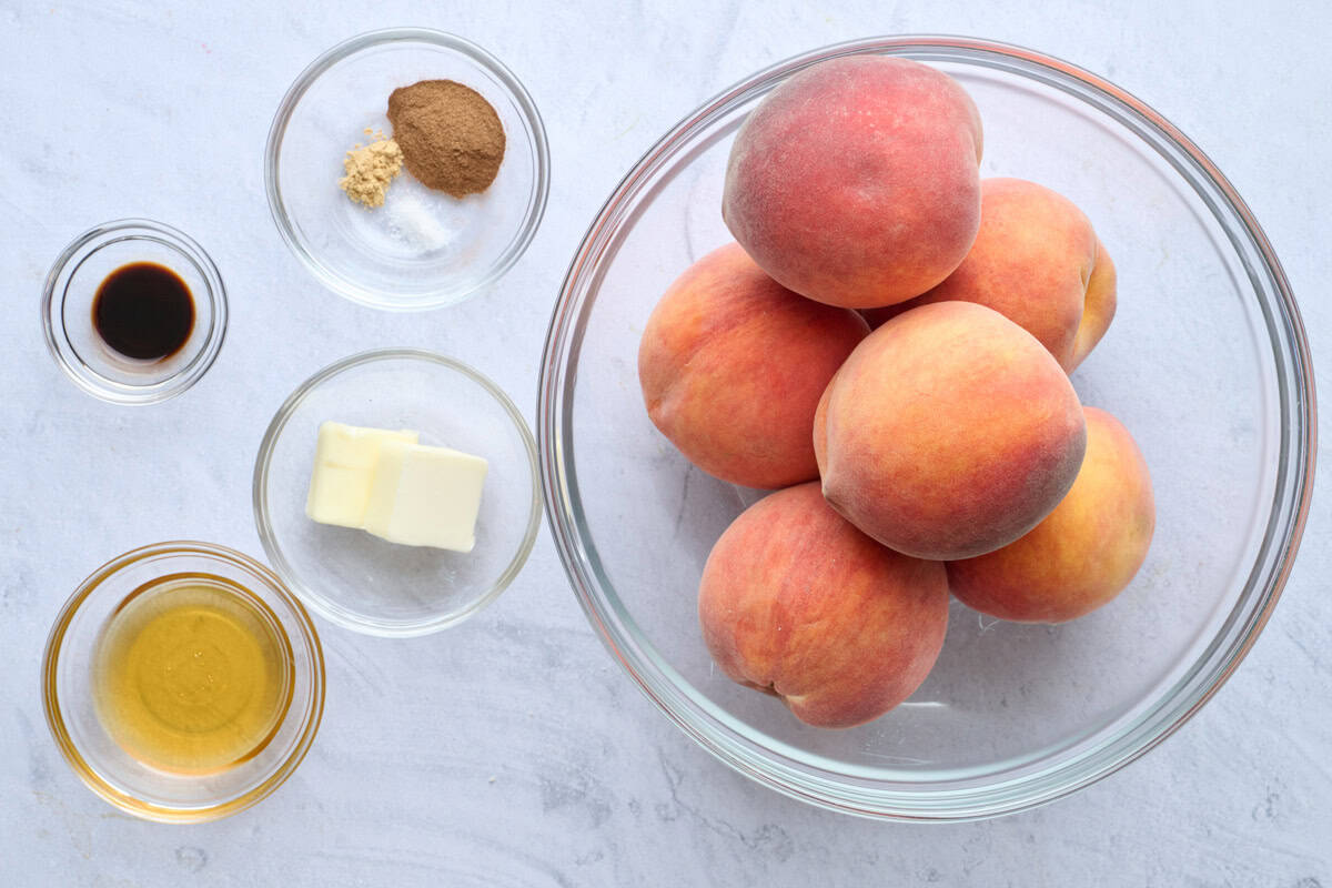 Ingredients for recipe: bowl of freestone peaches, butter, honey, vanilla extract, cinnamon, ginger, and salt.