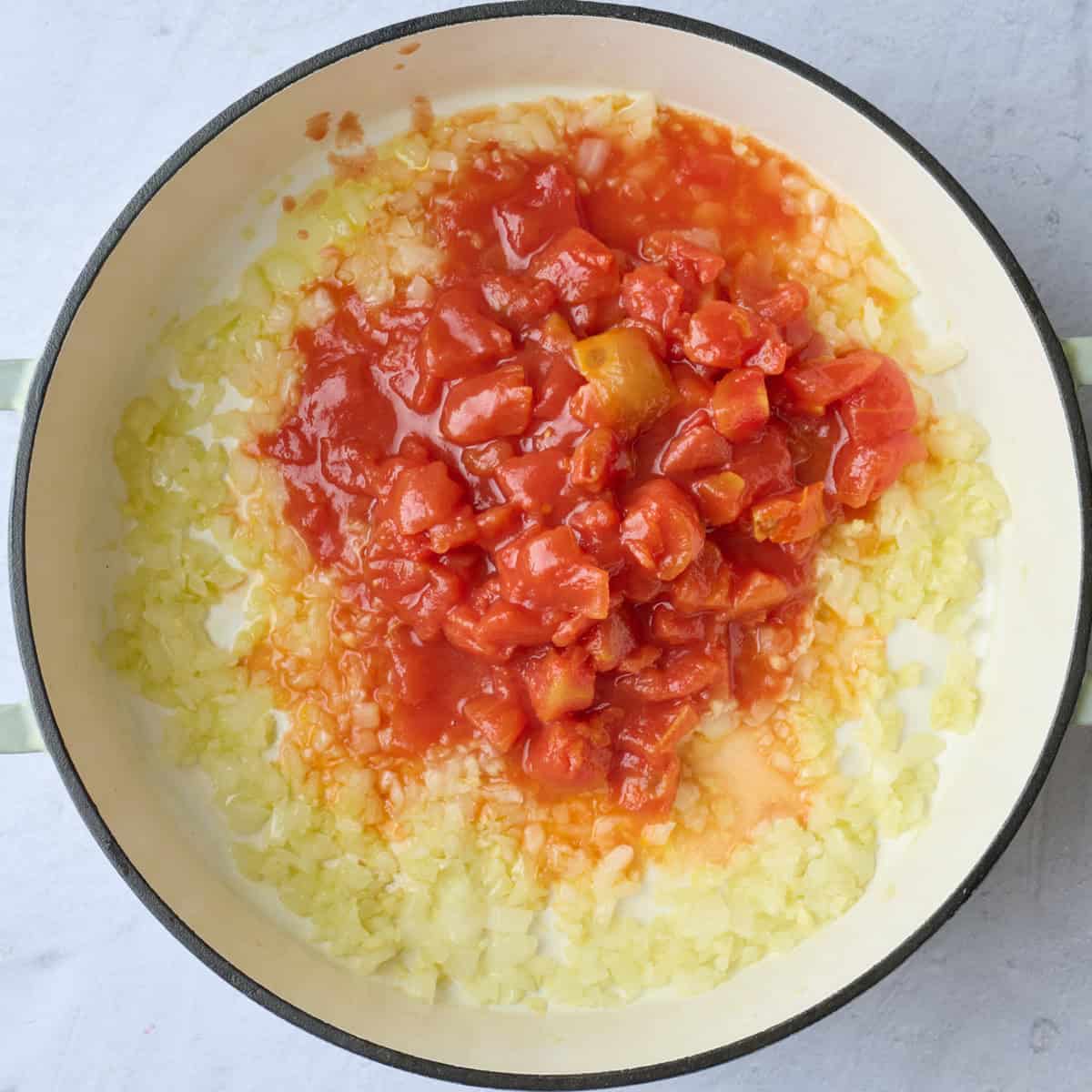 Canned diced tomatoes added to garlic and onion after cooking.