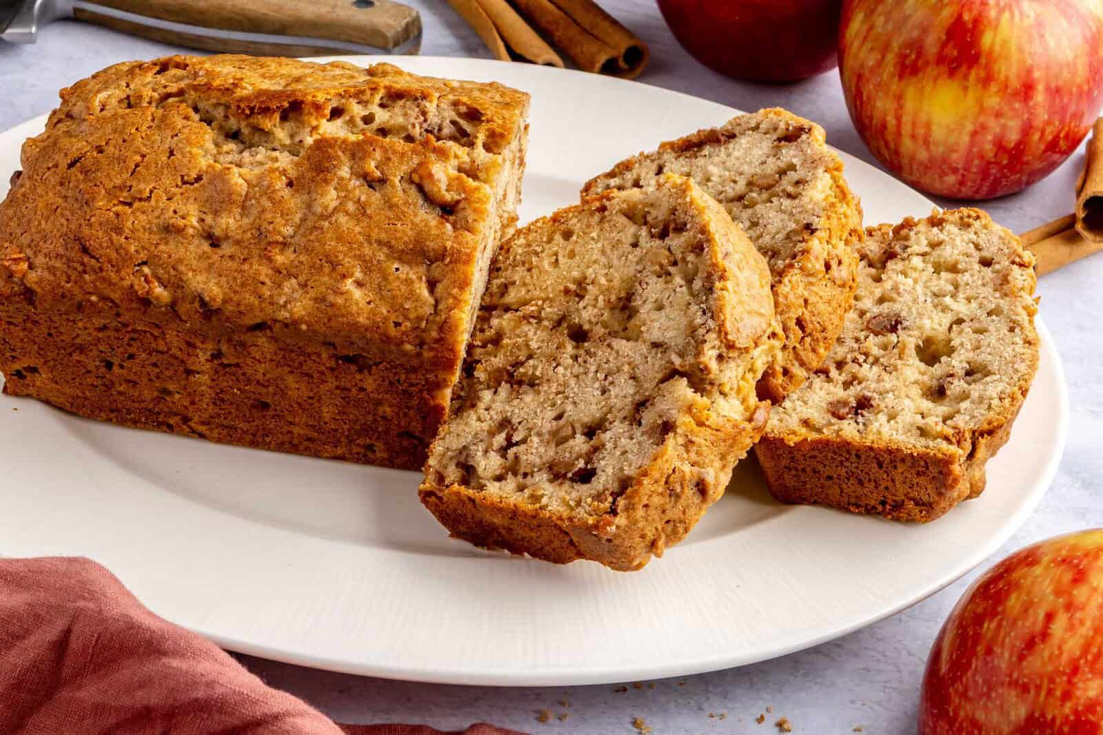 Easy apple bread recipe on a platter with a few thick slices cut.