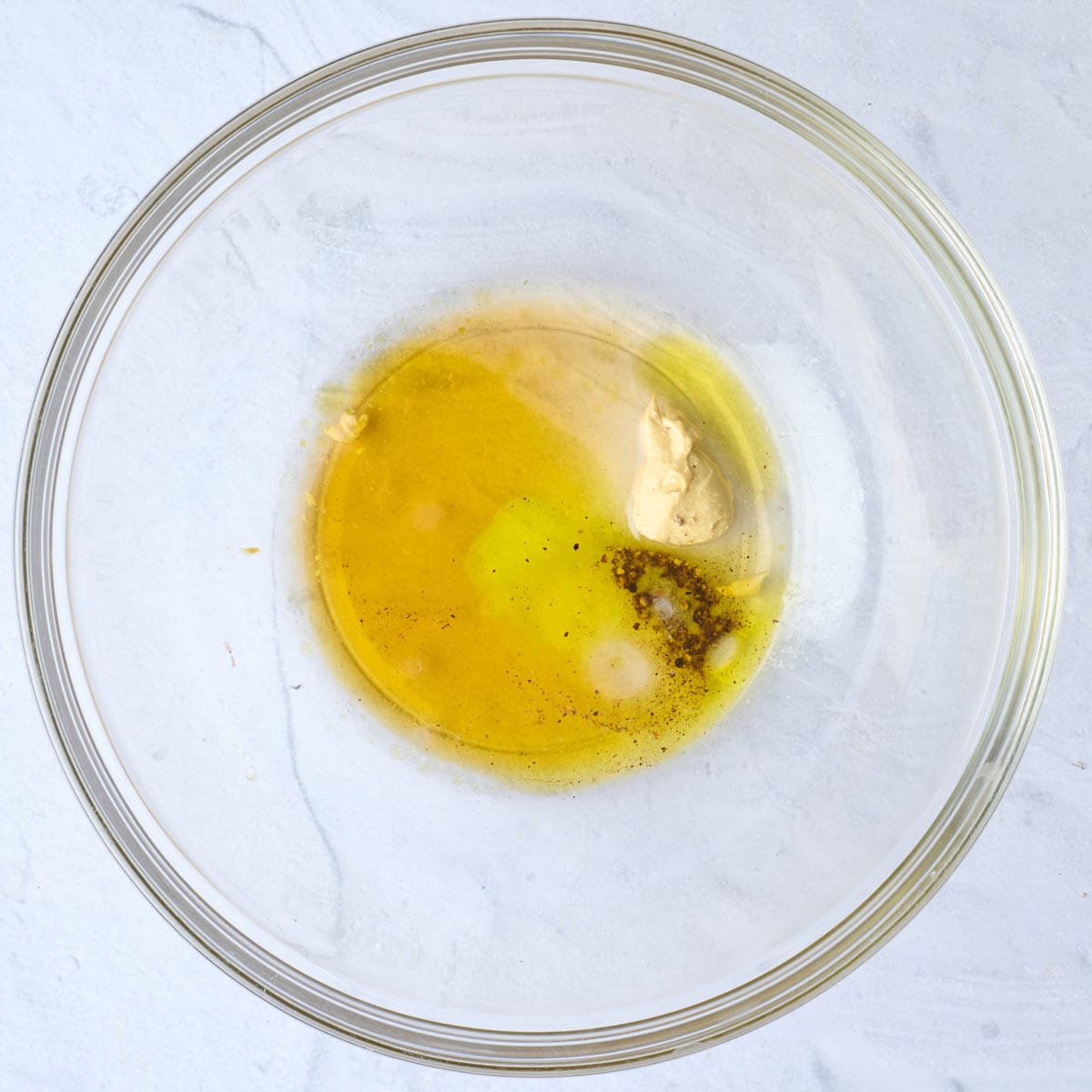 Dressing ingredients in a mixing bowl before mixing.
