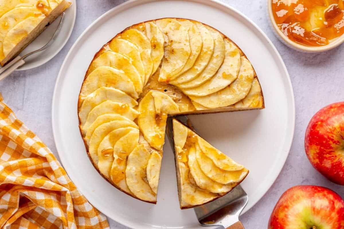 Cinnamon apple cake on a plate with a slice cut and spatula under a slice.