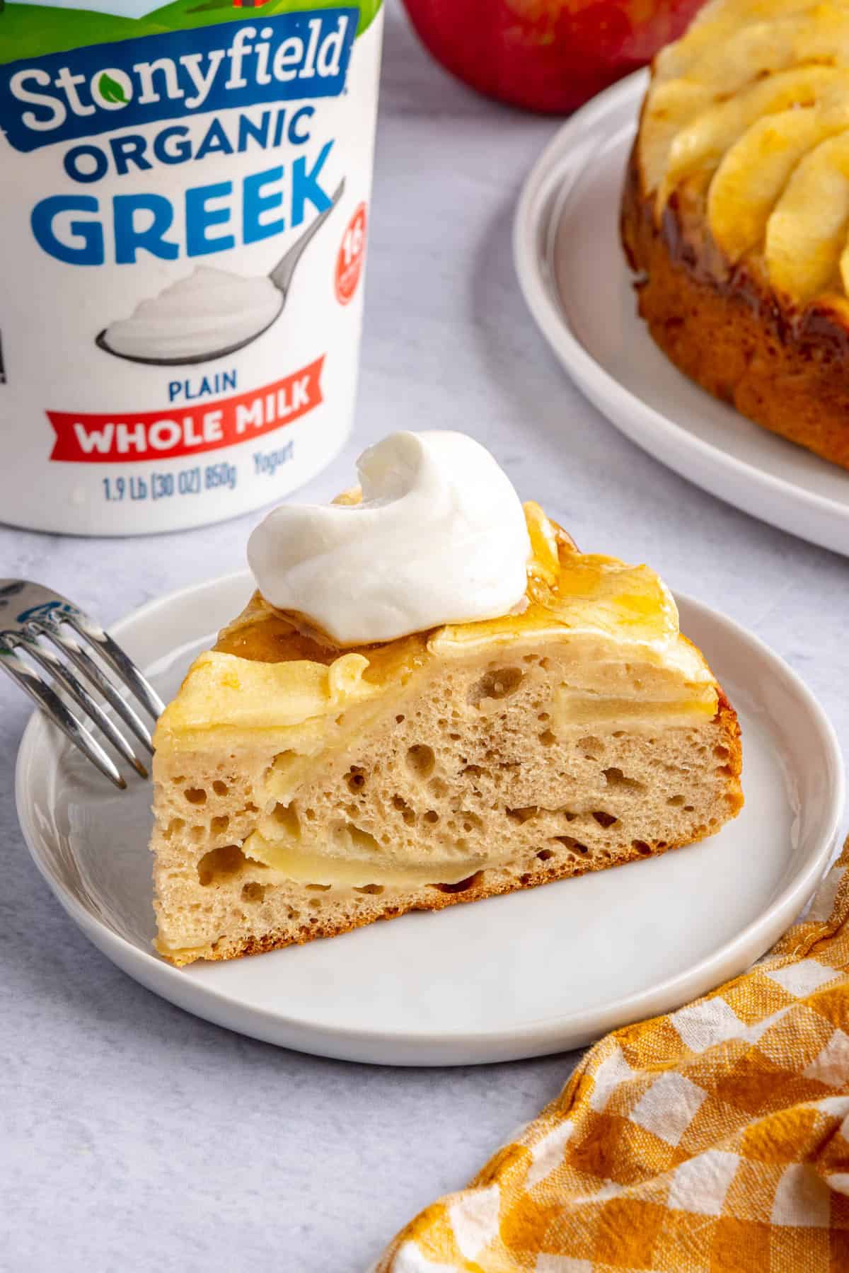 Slice of homemade apple cake made with Stonyfield Organic whole milk Greek Yogurt on a small plate.