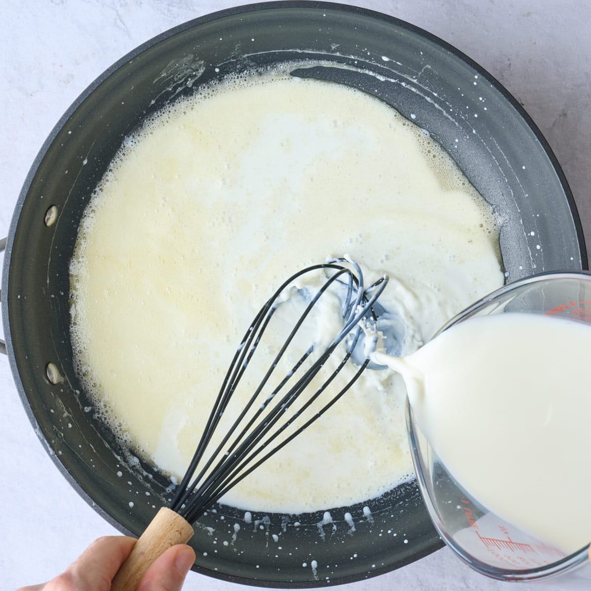 Whisking milk into roux.