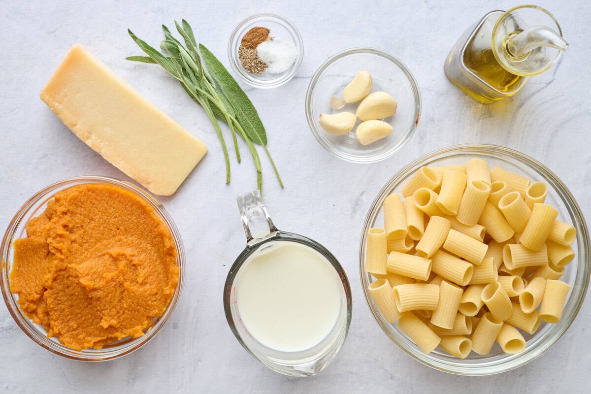 Ingredients for recipe: pumpkin puree, parmesan cheese, sage leaves, milk, seasonings, garlic, rigatoni pasta, and oil.