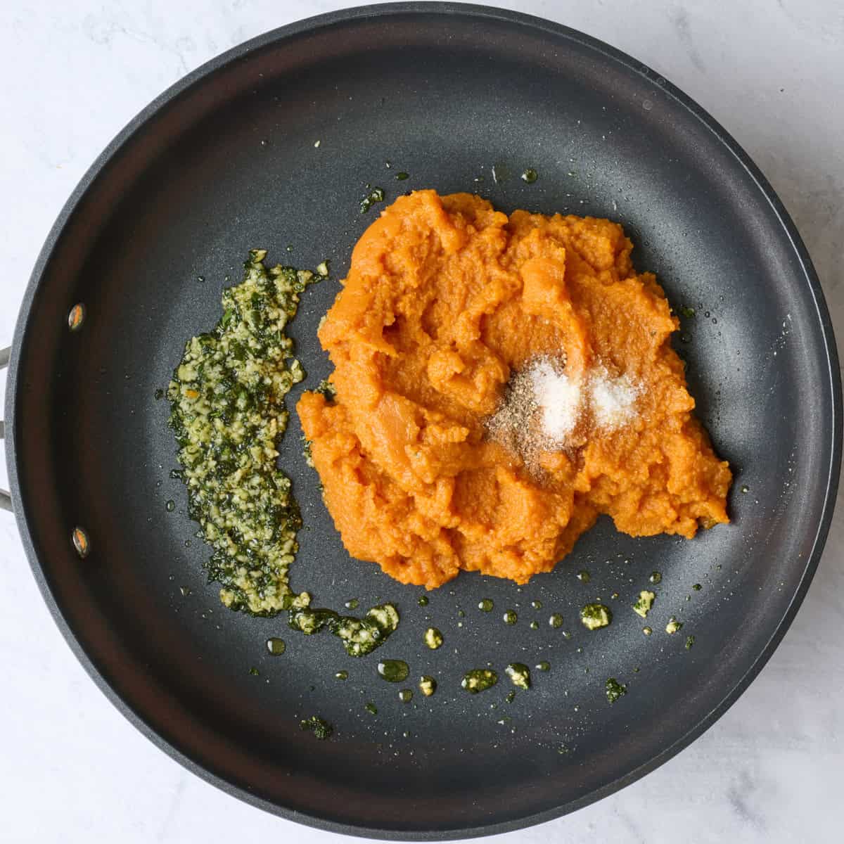Pumpkin, salt and pepper added to skillet with garlic and herbs.