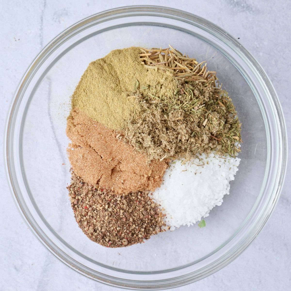 Kosher salt, brown sugar pepper and herbs in a small bowl.