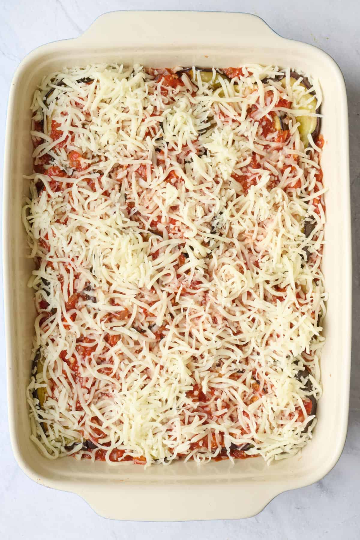 Another layer of sauce added with cheese on top.