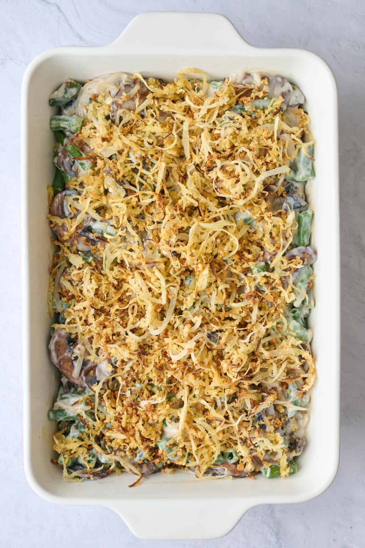 Prepared casserole with onion topping before baking.