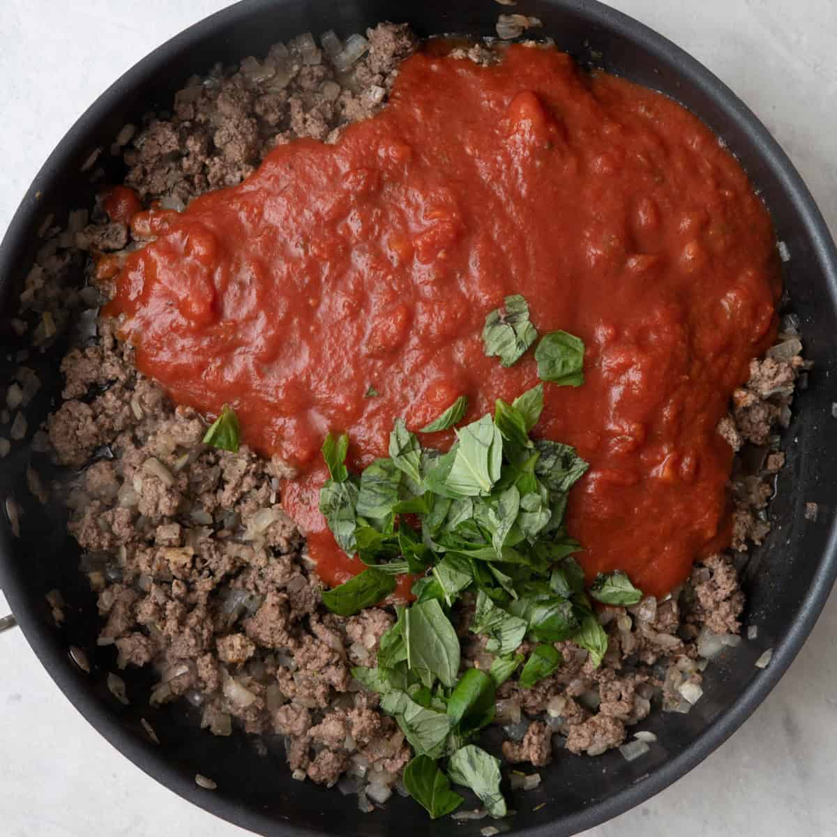 Marinara and basil added to ground beef mixture cooked with garlic.