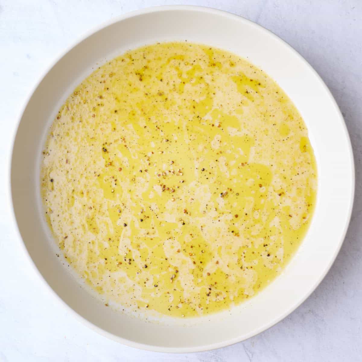 Oil, juice, salt and pepper in a large bowl for Jennifer Aniston salad dressing.