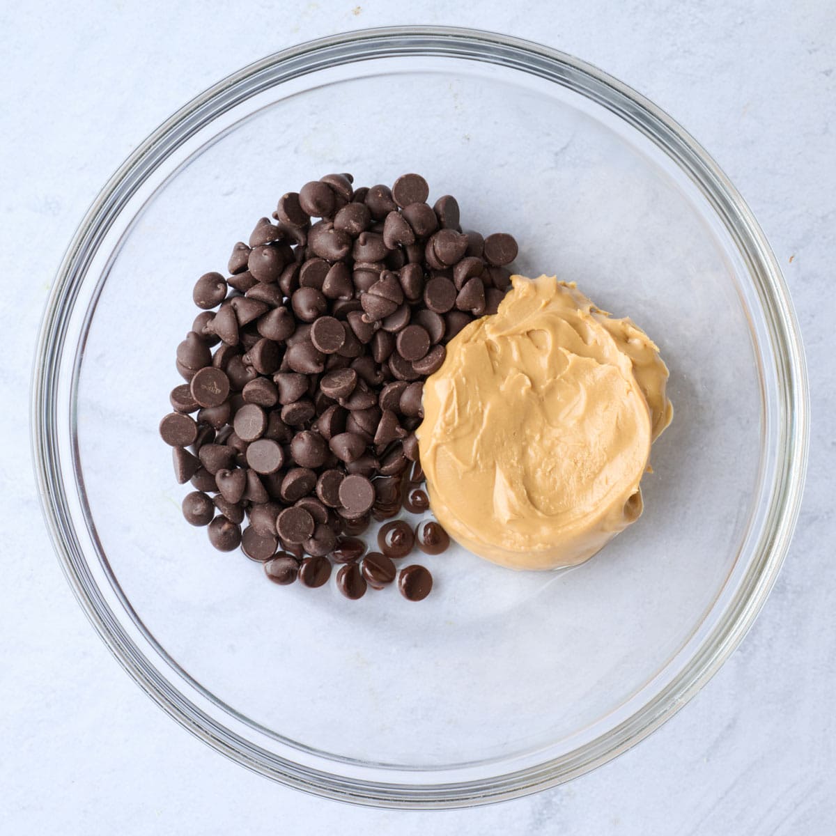 Chocolate chips, peanut butter and coconut oil in a bowl before melting.