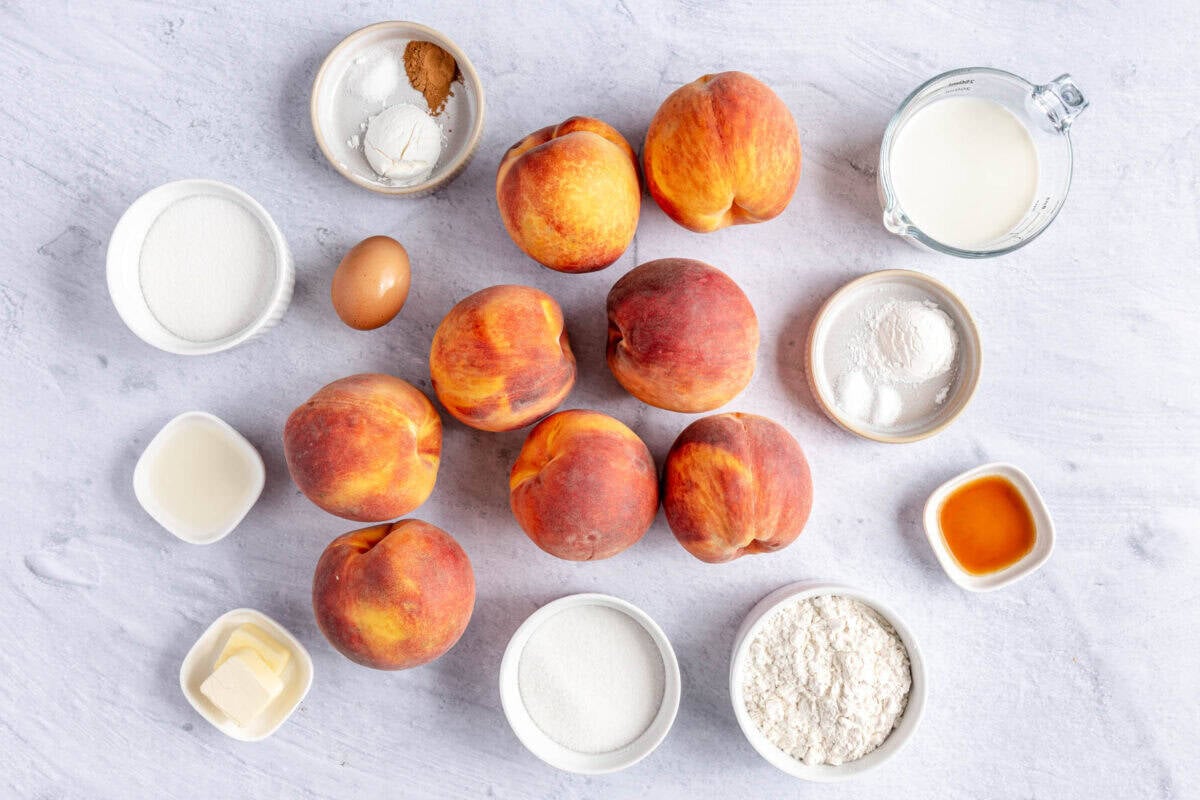 Ingredients for recipe: peaches, cinnamon salt, and cornstarch, sugar, lemon juice, butter, flour, vanilla, and milk.