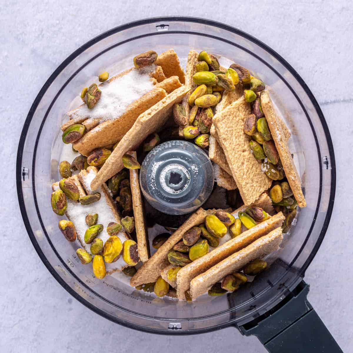 Graham crackers, pistachios, sugar and salt in the bowl of a food processor.