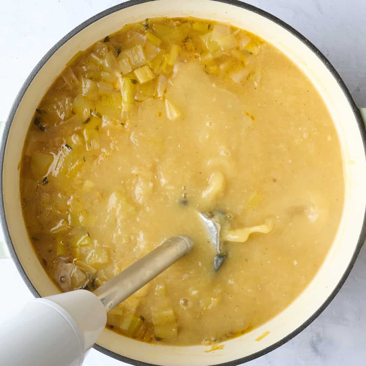 After soup has cooked with bay leaf removed and immersion blended inside pot, partially blended.