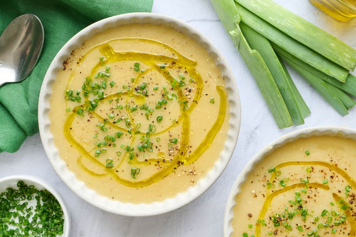 Easy potato leek soup garnished with a drizzle of oil and chopped chives.