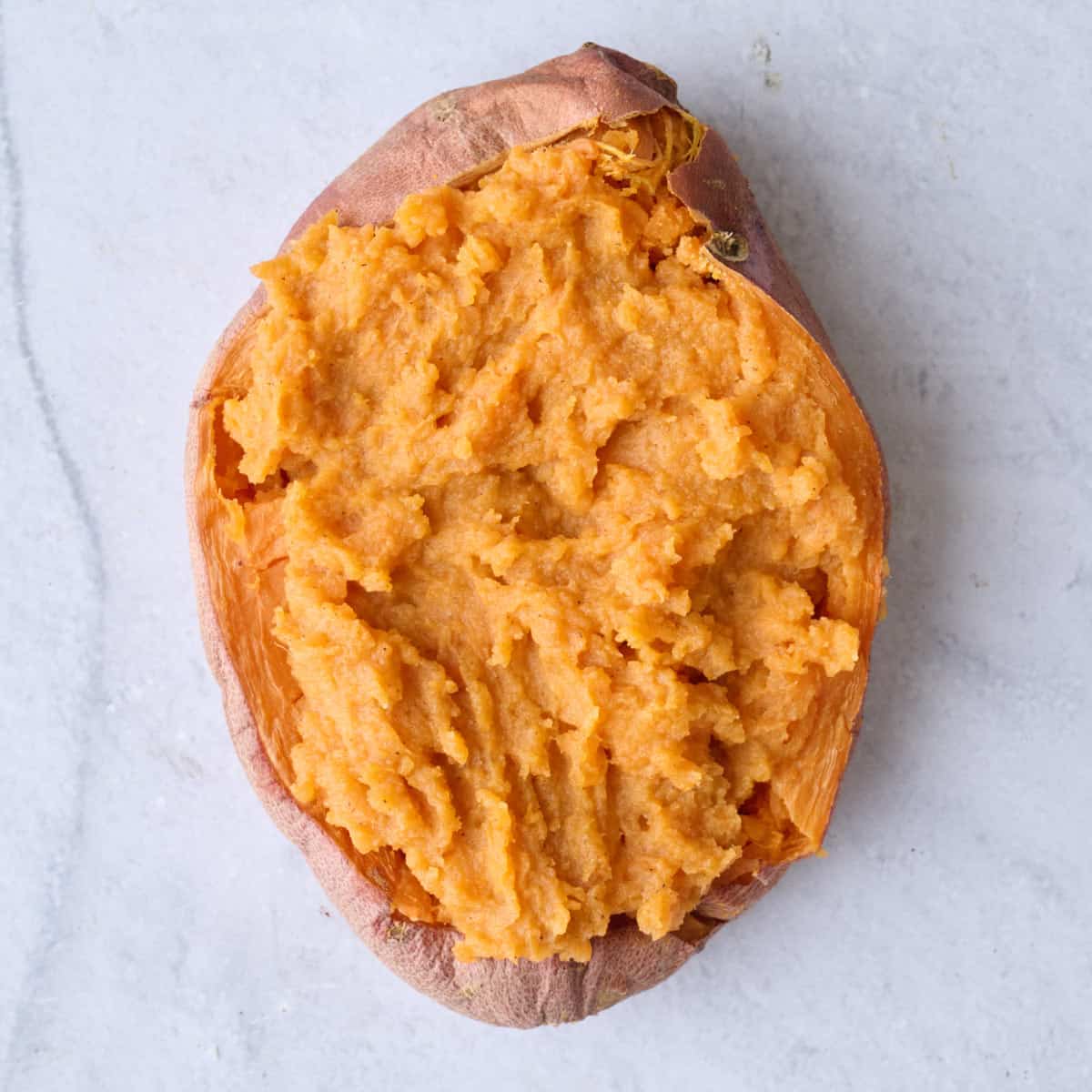 A sweet potato half filled with creamy mixture.