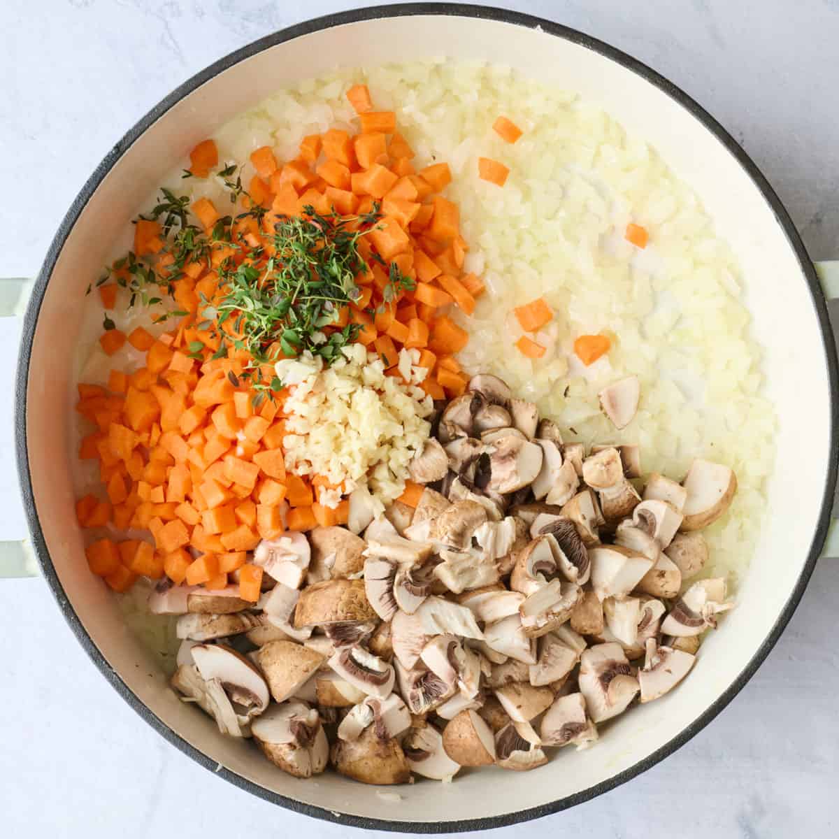 Diced veggies, garlic and herbs in a pot before cooking..