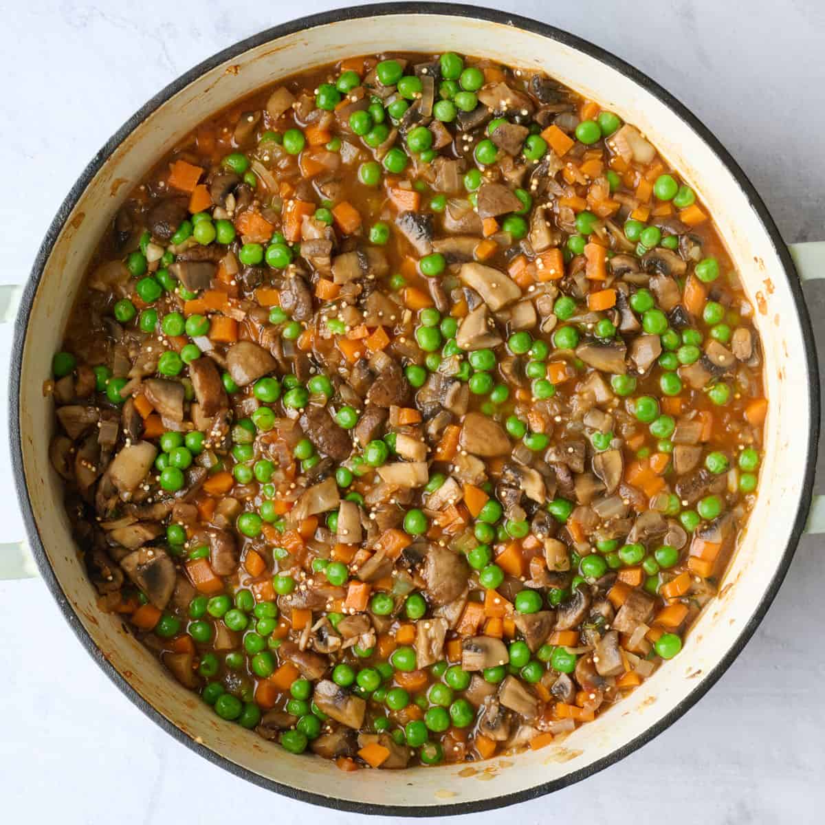 Recipe filling in pot after combining with veggies, broth and quinoa.