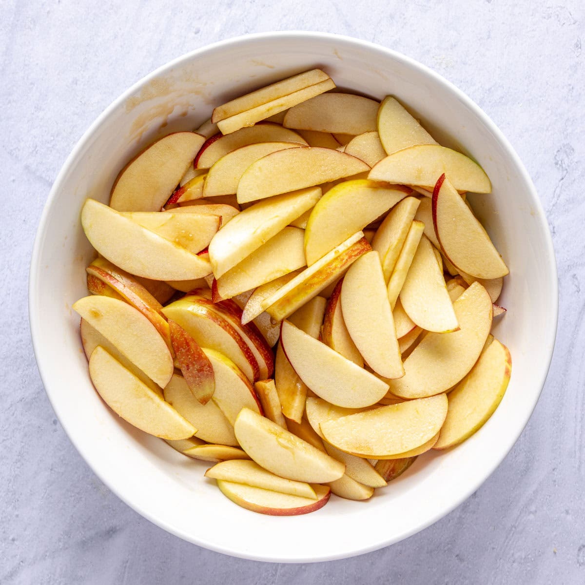Apples coated in a brown sugar mixture for apple tart recipe.